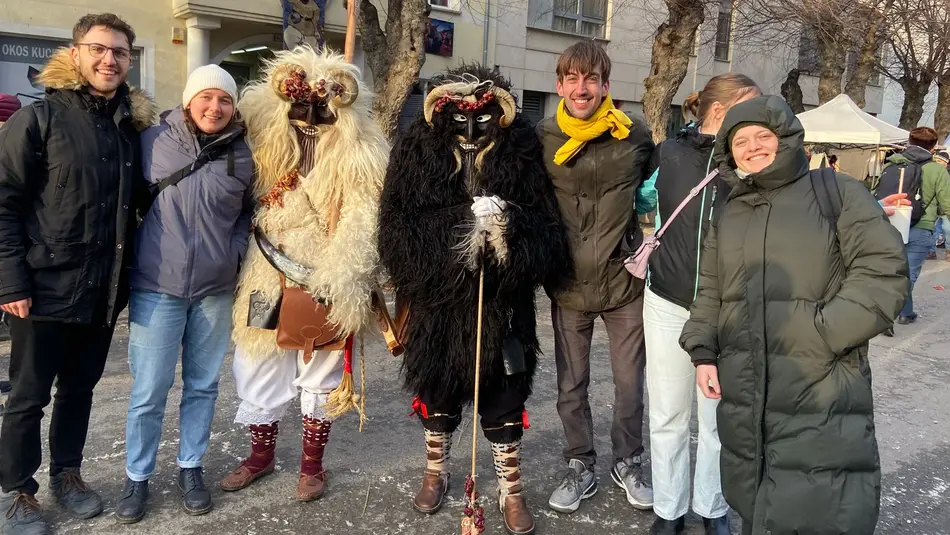 Erasmus-Studierende der Hochschule Trier auf enem Gruppenfoto mit maskierten Teilnehmern eines Karnevalumzuges in Ungarn 