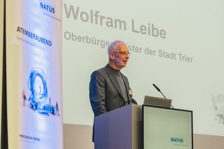 Oberbürgemeister Wolfram Leibe spricht ein Grußwort vom Rednerpult der Bühne.