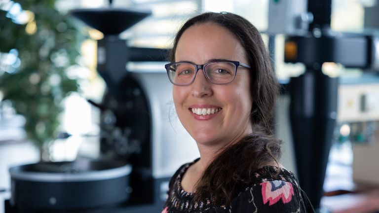 Portraitbild vor dem Kaffeeröster von Verena Eisner, Dozentin in der Fachrichtung Lebensmitteltechnik